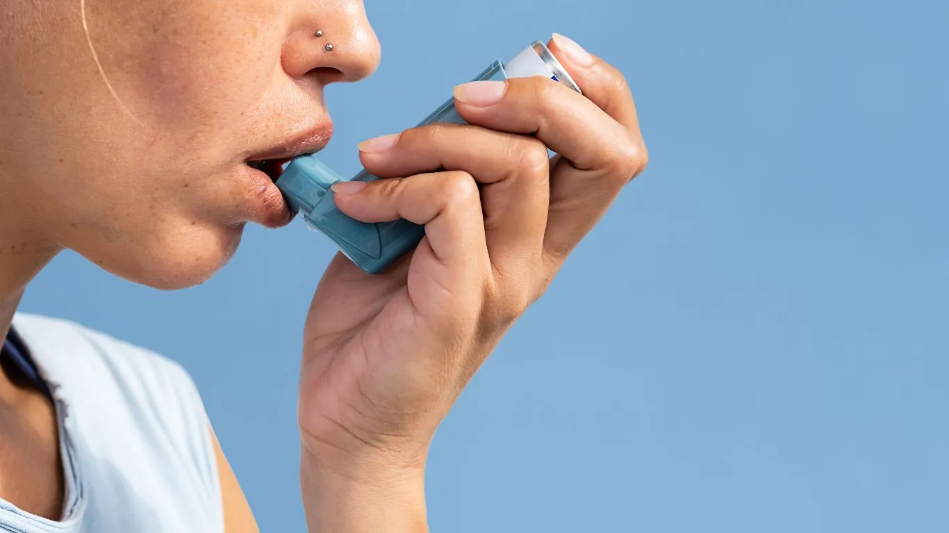 A person wearing a mask while cleaning with asthma-safe products