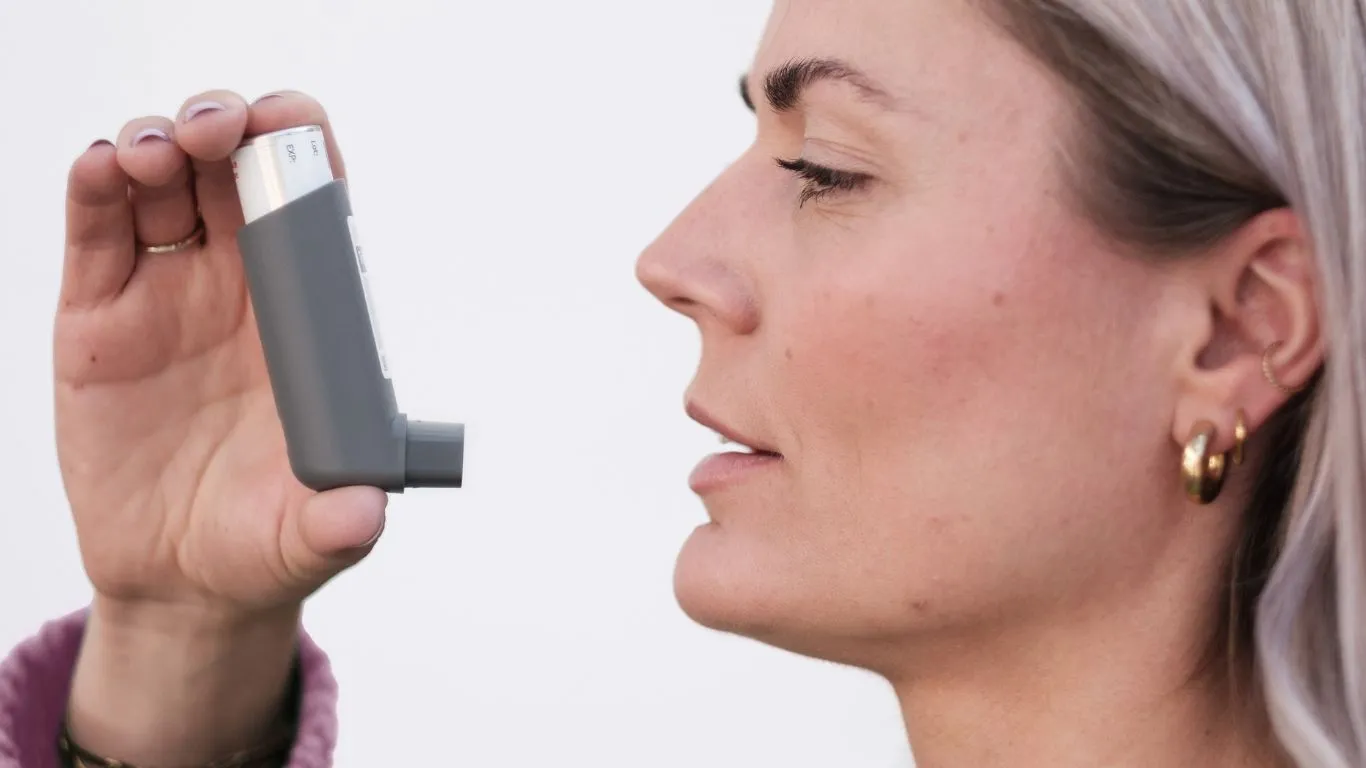 Person holding inhaler for asthma relief