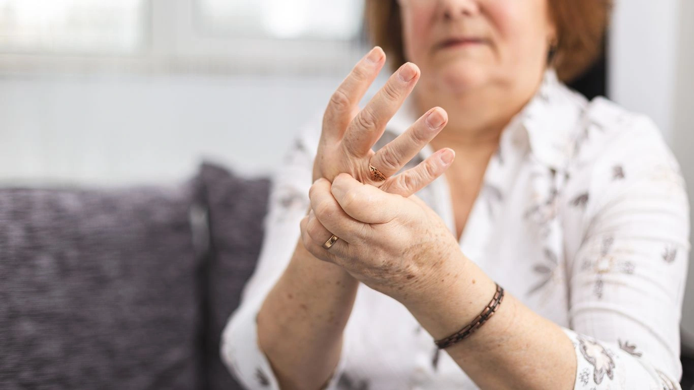 A person experiencing joint pain due to rheumatoid arthritis.