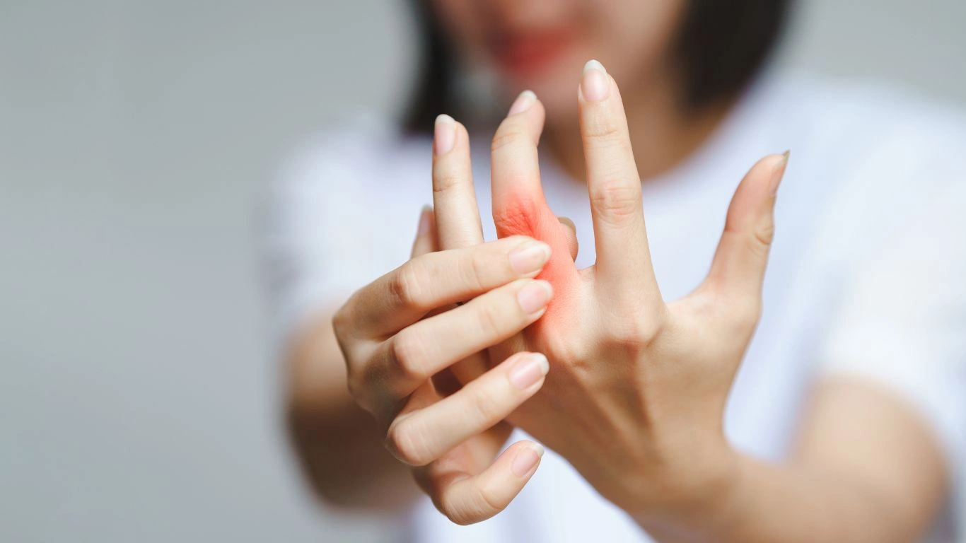 A person stretching their hands to relieve pain from rheumatoid arthritis.