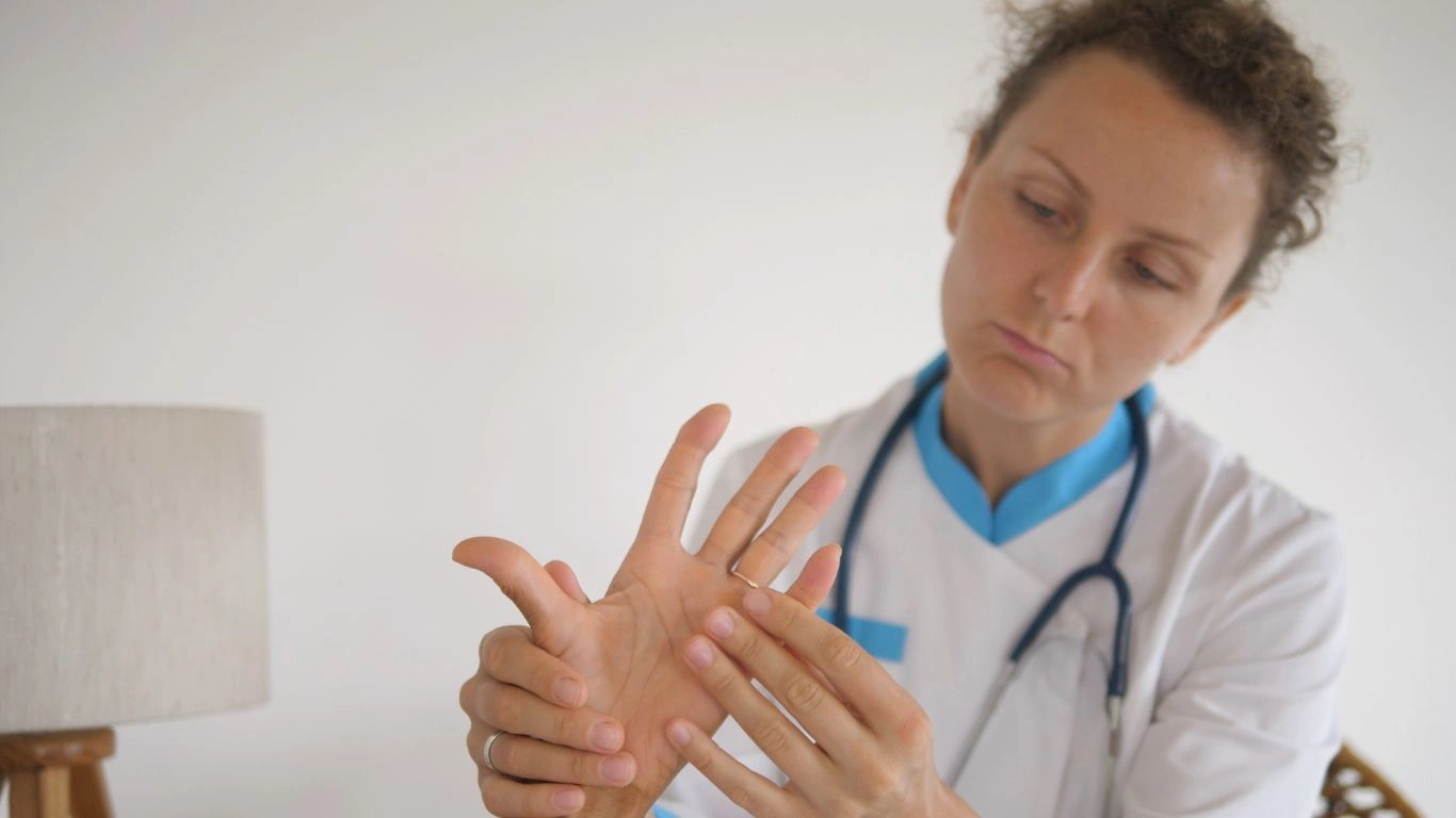 Person experiencing joint pain in their hand due to rheumatoid arthritis