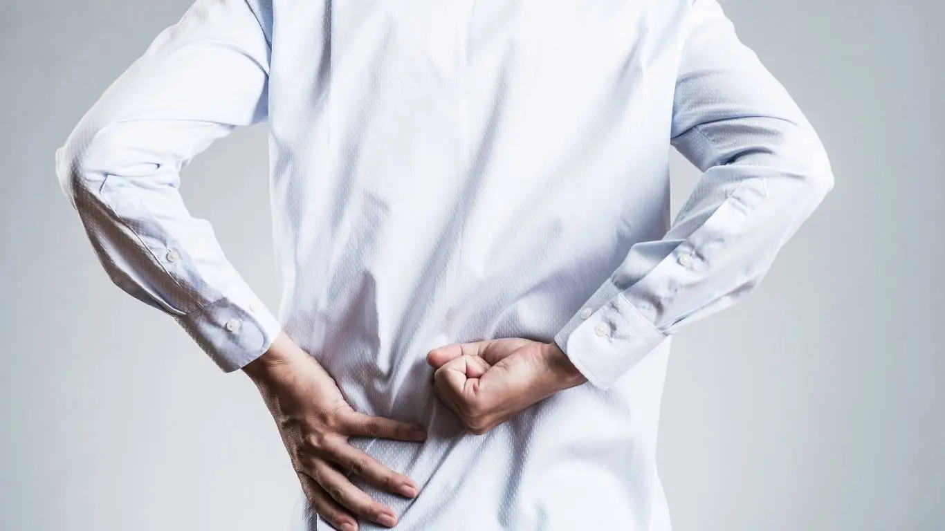 Gamer using standing desk and lumbar support during play